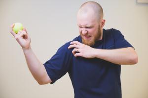 mies pitelee olkapäätään